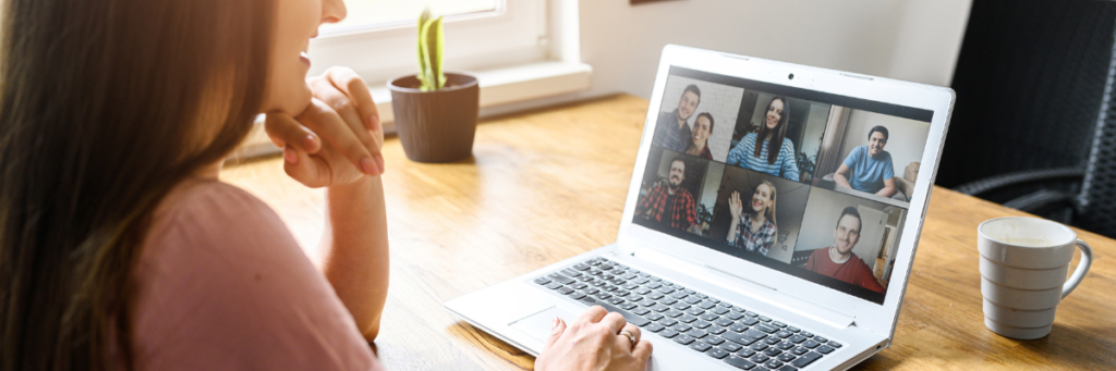 A woman uses her laptop to attend a virtual meeting.