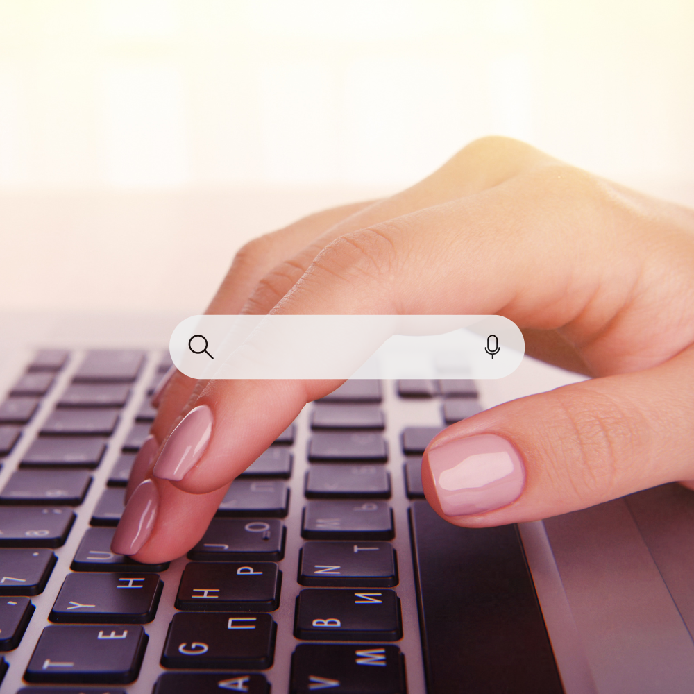 A close up of a hand typing on a laptop keyboard.